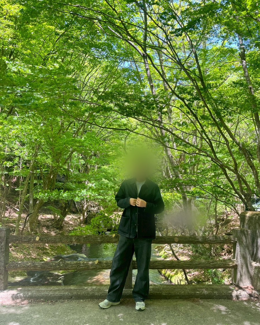 新緑の森の中、橋の上に立っている写真(顔にはぼかし加工済み)